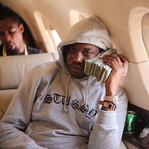 Meek Mill with money by face